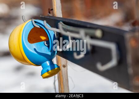 Alte Kinder Gießkanne hängen an einem Kleiderbügel in der Gemüsegarten Stockfoto