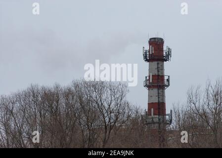 Ziegelrohr mit Telekommunikationsausrüstung. Zelluläre Ausrüstung auf dem CHPP-Rohr. Stockfoto