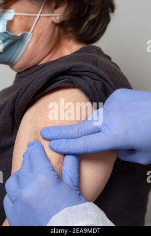 Doktor, der der älteren Frau Schüsse verabreichte Stockfoto