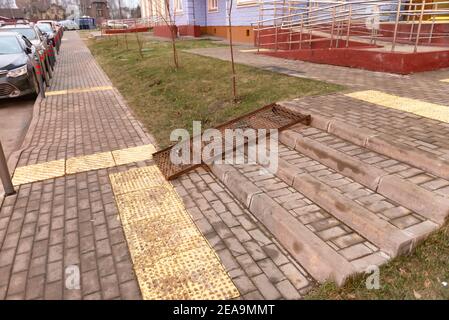 Elemente einer barrierefreien Umgebung. Metallrampe und taktile Fliesen auf dem Bürgersteig. Stockfoto