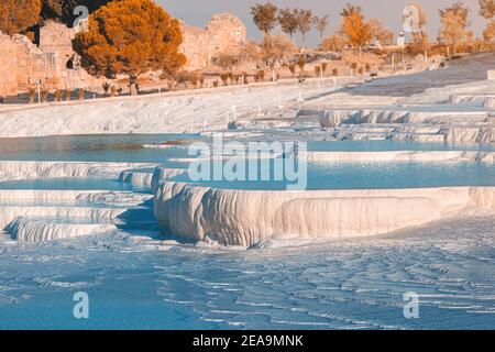 Berühmte Travertinen im türkischen Ferienort Pamukkale in der Nähe der Stadt Denizli. Aufschlüsse von weißem Mineralgestein und Thermalwasserquellen. Wunder der Natur Stockfoto