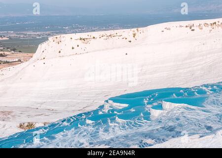 Berühmte Travertinen im türkischen Ferienort Pamukkale in der Nähe der Stadt Denizli. Aufschlüsse von weißem Mineralgestein und Thermalwasserquellen. Wunder der Natur Stockfoto