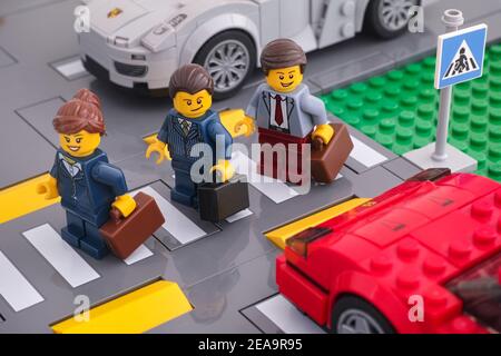 Tambow, Russische Föderation - 07. Februar 2021 Lego Geschäftsleute minifiguren über die Straße mit einem Fußgängerübergang. Stockfoto