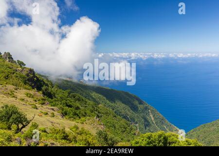 Blick vom Plateau in Fanal, Madeira, Portugal auf den blauen Atlantik mit Wolken am Berghang Stockfoto