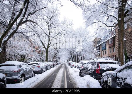 Brooklyn, NY - Februar 7 2021: Winterszene mit schneebedeckten Autos, die entlang der Straßen in Brooklyn, NY, geparkt sind Stockfoto