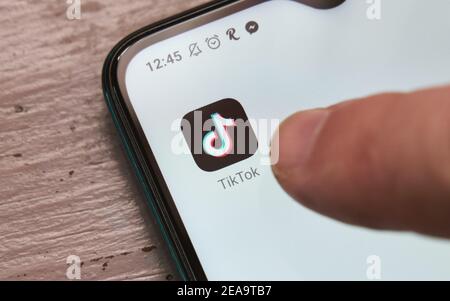 Crop anonyme Person berühren Symbol von TikTok mobile App für Video-Sharing auf dem modernen Smartphone, Mexiko, im Februar 8, 2021 Stockfoto