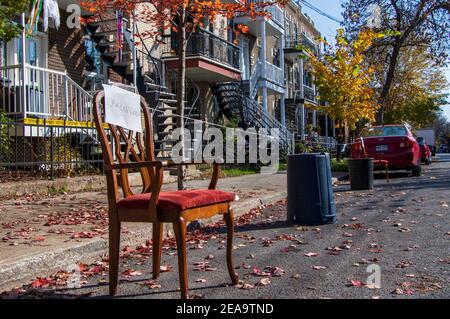 23. Oktober 2020- Montreal, QC, Kanada: Moving Day Zeichen auf einem Stuhl und Mülleimer, um Parkplatz auf einer engen Straße im Herbst zu reservieren Stockfoto