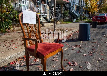 23. Oktober 2020- Montreal, QC, Kanada: Moving Day Zeichen auf einem Stuhl und Mülleimer, um Parkplatz auf einer engen Straße im Herbst zu reservieren Stockfoto