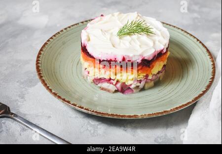 Russische traditionelle Neujahr Salat Hering unter Pelzmantel auf Rustikaler Betontisch Stockfoto