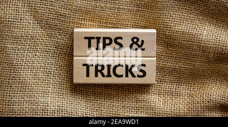 Symbol „Tipps und Tricks“. Holzblöcke mit den Worten "Tipps und Tricks". Schöner Leinwandhintergrund. Business, Tipps und Tricks Konzept. Speicherplatz kopieren. Stockfoto