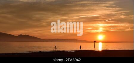 Nehmen Sie sich am Ende des Tages Zeit, um den Sonnenuntergang zu sehen. Das Feuer brennt und vielleicht fangen Sie Zeit. Stockfoto