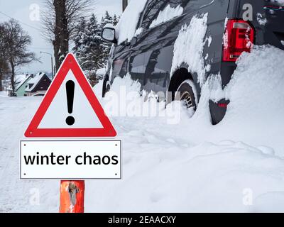 Warnschild 'Winter Chaos' Auto im Schnee stecken Stockfoto