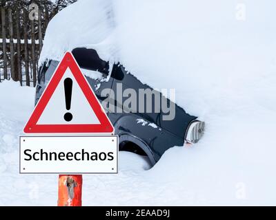 Auto im Schnee stecken mit Warnschild in deutsch Stockfoto