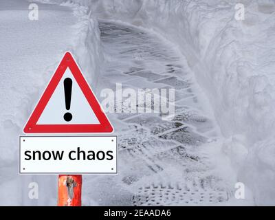 Gehweg im Winterchaos mit Warnschild Stockfoto