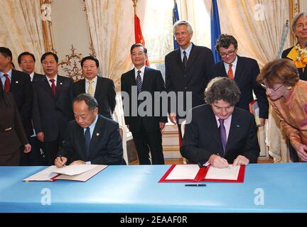 Der französische Wirtschafts-, Finanz- und Industrieminister Thierry Breton (R) und sein chinesischer Amtskollege unterzeichnen einen Vertrag, während der chinesische Premierminister Wen Jiabao (Hintergrund L) und Frankreichs Premierminister Dominique de Villepin (C) bei einer Zeremonie, bei der China 150 Airbus A320-Flugzeuge bestellte, Im Hotel Matignon in Paris, Frankreich, am 5. Dezember 2005. Foto von Bruno Klein/ABACAPRESS.COM Stockfoto