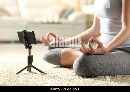 Nahaufnahme einer Frau, die Yoga macht und online-Videos ansieht Tutorial auf Handy zu Hause Stockfoto