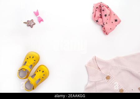 Kinderkleidung und Schuhe auf weißem Hintergrund Draufsicht. Leerzeichen für den Text. Stockfoto