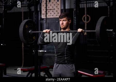 Sportler Hantelhantel im Cross-Fit-Fitness-Studio, Bodybuilding und Gewichtheben Konzept. Männlich in Sportbekleidung im Crossft-Training beschäftigt, Training allein Stockfoto