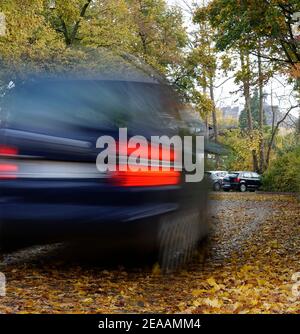 Deutschland, Bayern, Herbstlaub auf der Straße, Landstraße, Laubbäume, fahrendes Auto, Rutschgefahr Stockfoto