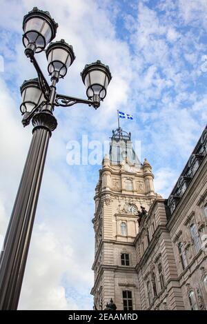 Eine Würmer-Ansicht des Uhrturms mit einem verzierten Lampenpfosten im Quebec Parlimnet Building, Quebec City. Stockfoto