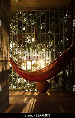 Hängematte beleuchtet zur goldenen Stunde auf sicherer Veranda Stockfoto