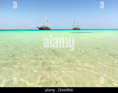 Zwei Segelboote im türkisfarbenen Meer unter Sonnenlicht Stockfoto