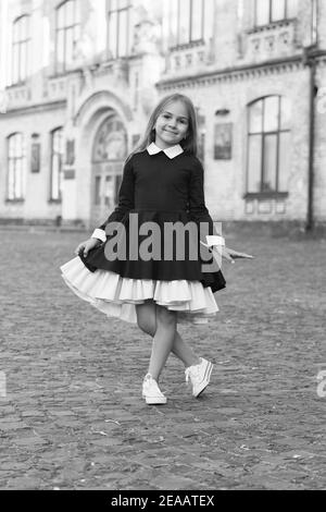 Seine Freude an Eleganz. Happy Kid machen Curtsy in Uniform im Freien. Einheitliche Kleiderordnung. Bekleidungsstandards. Mode Schuluniform. Formeller Stil. Grundschulbildung. September. Stockfoto