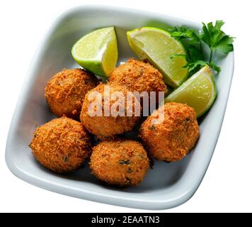 Salz Kabeljau fritters mit Zitronenstücken auf weiß isoliert Hintergrund Stockfoto