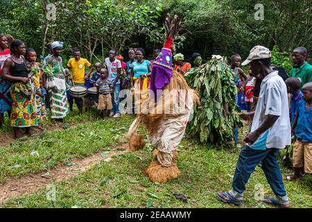 Menschen tanzen in der westlichen Region Rural, Sierra Leone. Die Menschen in Sierra Leone sind in ihren Traditionen verwurzelt. Die Balui-Tänzerin sorgt für Entspannung. Falui Scroll hat eine unterhaltsamere Funktion. Der Kopf ist mit farbigen Tüchern bedeckt und mit Kauri-Muscheln und Spiegeln verziert. Sie hat eine konische Form und hat Federn auf der Oberseite Stockfoto