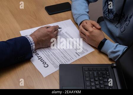 Unterzeichnung von Verträgen EIN junger Mann bereit, ein zu unterzeichnen Vertrag von einer Firma oder einem Notar für geschäftliche Zwecke Stockfoto