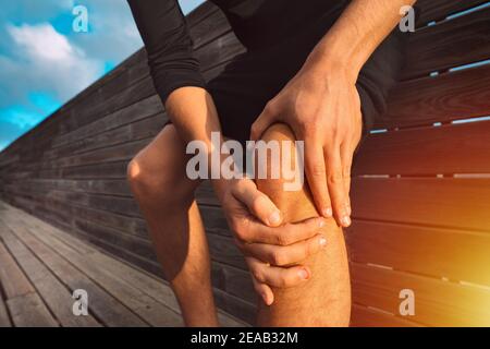 Mann, der sein schmerzhaftes Knie hält. Knieverletzung und Schmerzen des Sportlers. Verletzung durch Training Stockfoto