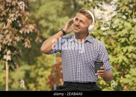 Vorteile für Remote-Arbeit. Kaffeepause. Belohnen Sie sich und ermutigen. Mann trinkt Kaffee hören Lieblingsmusik Künstler. Mittagszeit. Kaffee im Freien Natur Hintergrund. Inspiriert von der Umwelt. Stockfoto