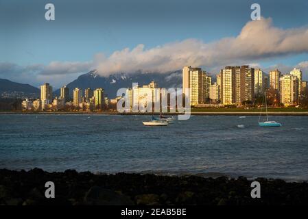 Vancouver English Bay Sonnenuntergang. Segelboote ankerten in English Bay. Im Hintergrund sind die schneebedeckten North Shore Mountains. Vancouver, British Colum Stockfoto