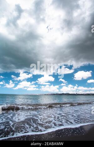 Dunkle Sturmwolken über dem wunderschönen schwarzen Sandstrand und dem Meer Am Ufer von Puerto Rico aus gesehen Stockfoto