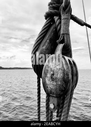 Hölzerne Schiffsblöcke, die mit Seilen auf dem historischen Kaufmann befestigt sind Schiff Lisa von Lübeck Stockfoto