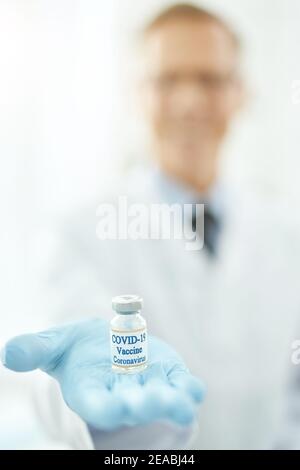 Arzt Hand in sterilen Handschuh mit Flasche Coronavirus-Impfstoff Stockfoto