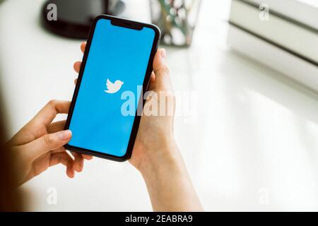 Bangkok, Thailand - Januar 25, 2021 : Frau mit Smartphone öffnen Twitter-Anwendung zeigt auf dem Bildschirm, Online-Social-Networking und Service, die en Stockfoto