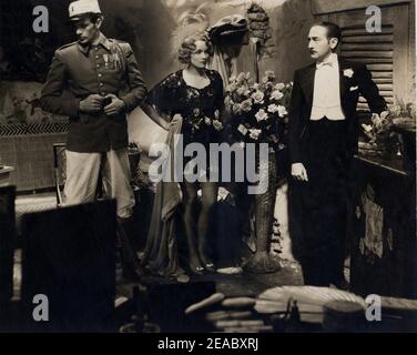 1930 , USA : die Filmschauspielerin MARLENE DIETRICH ( 1902 - 1992 ) mit GARY COOPER und ADOLPHE MENJOU in MAROKKO ( Marokko ) von Josef VON STERNBERG , Paramount Bild - KINO - FILM - Kleidung - Portrait - ritratto - Gambe - langbeinige Pose - Beine - calze di seta nere - schwarze Seidenstrümpfe - divisa militare uniforme - militärische Uniform - Legione straniera - Rose - fiori - Blumen - Haare blond - Blondie - bionda - capelli biondi - Rauchen - Kamelien - Pochette - camerino ---- Archivio GBB Stockfoto