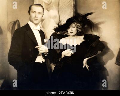 1933 , USA : die Filmschauspielerin MARLENE DIETRICH ( 1902 - 1992 ) und Brian AHERNE in LIEDERN ( Il cantico dei cantici ) von Rouben Mamoulian , Paramount Picture - KINO - FILM - Attrice - Portrait - ritratto - hair blonde - Blondie - bionda - capelli biondi - Locken - riccioli - scollatura - decolleté - Halsausschnitt - Ausschnitt - Rauchen - papillon - cravatta - Krawatte - Kragen - colletto - Hut - cappello Con piume - Federn - sigaretta - Zigarette - fumatore - Raucher - fumo - Rauch - celebrità attori personalità che fumano - Prominente Schauspieler Raucher ---- Archivio GBB Stockfoto