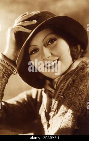 1930 , USA : Die Schauspielerin GRETA GARBO in ANNA CHRISTIE von Clarence Brown , aus einem Theaterstück von Eugene O' Neill - MGM - FILM - FILM - KINO - Portrait - ritratto - hat - cappello - O'Neill - maglia - maglione - tricot - foulard - smile - sorriso ---- Archivio GBB Stockfoto