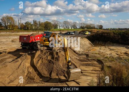 Oberhausen, Ruhrgebiet, Nordrhein-Westfalen, Deutschland - Bagger bei Erdarbeiten im Rahmen des Emscher-Umbaus, Neubau des Emscher-AKE-Kanals, hier im Holtener Feld wird die Landschaft nach der Verlegung der vorgefertigten Rahmen-Doppelkanalteile neu gestaltet und neu gestaltet. Der ökologische Umbau des Emscher-Systems besteht aus dem Bau einer zentralen Abwasserreinigungsanlage im Ruhrgebiet, dem Bau von Kanalisation und der Renaturierung der Emscher und ihrer Nebenflüsse. Stockfoto