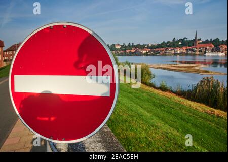 Verkehrsschilder auf dem Deich, Durchfahrt verboten, für Kraftfahrzeuge gesperrt, im Hafen von Hohnstorf mit Blick auf die Altstadt von Lauenburg in Schleswig-Holstein Stockfoto