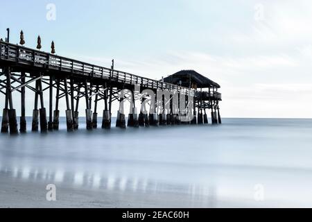 Sonnenaufgang am Cocoa Beach Pier, lange Exposition mit gefrorener Wasseroberfläche Stockfoto