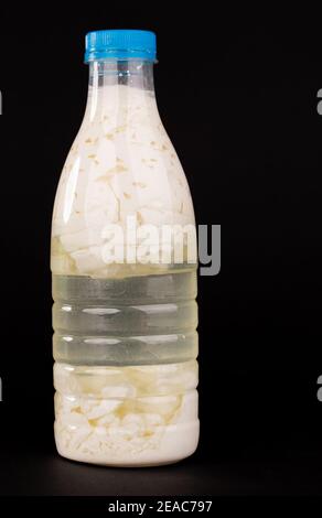 Saure Milch in einer Plastikflasche. Befindet sich auf dem schwarzen  Hintergrund Stockfotografie - Alamy