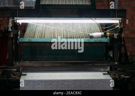 Nahaufnahme der alten Seidenweberei Maschine läuft, Herstellung von Seidentuch in Vietnam. Stockfoto