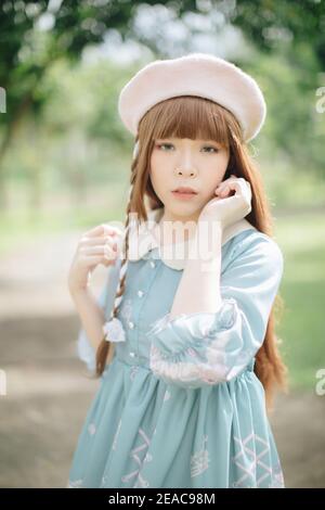 Portrait von asiatischen Mädchen in Lolita Mode Kleid im Garten Hintergrund Stockfoto