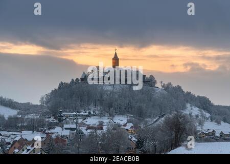 Sonnenuntergang hinter der verschneiten Leuchtenburg in Thüringen. Stockfoto