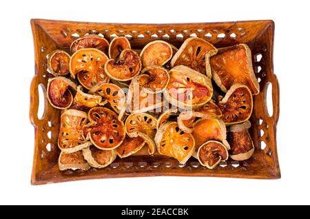 Holztablett mit getrockneten Bael Obst isoliert auf weißem Hintergrund. Studio Foto Stockfoto