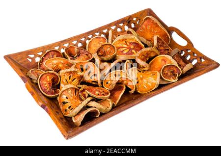 Holztablett mit getrockneten Bael Obst isoliert auf weißem Hintergrund. Studio Foto Stockfoto