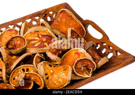 Holztablett mit getrockneten Bael Obst isoliert auf weißem Hintergrund. Studio Foto Stockfoto